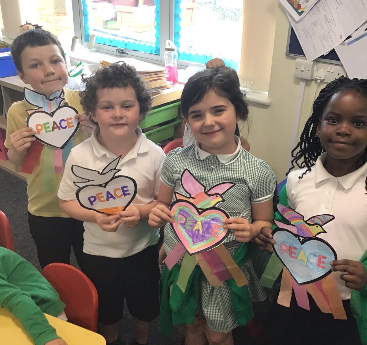 Four children holding doves with peace written on them